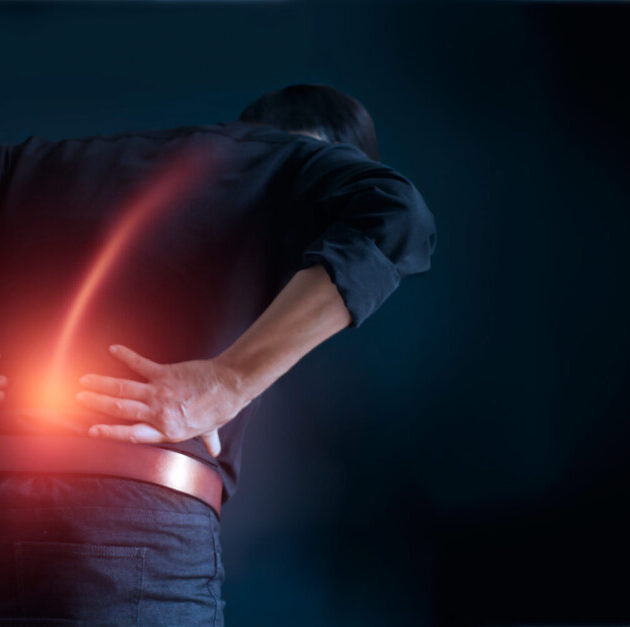 Man suffering from back pain cause of office syndrome, his hands touching on lower back. Medical and heathcare concept